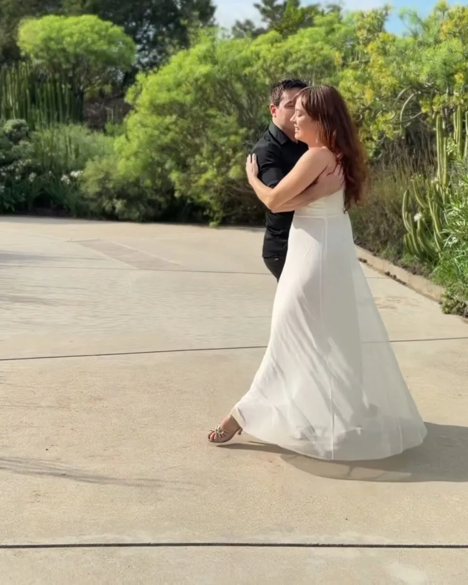 Pareja abrazada bailando la coreografía de Until I Found You en un jardín