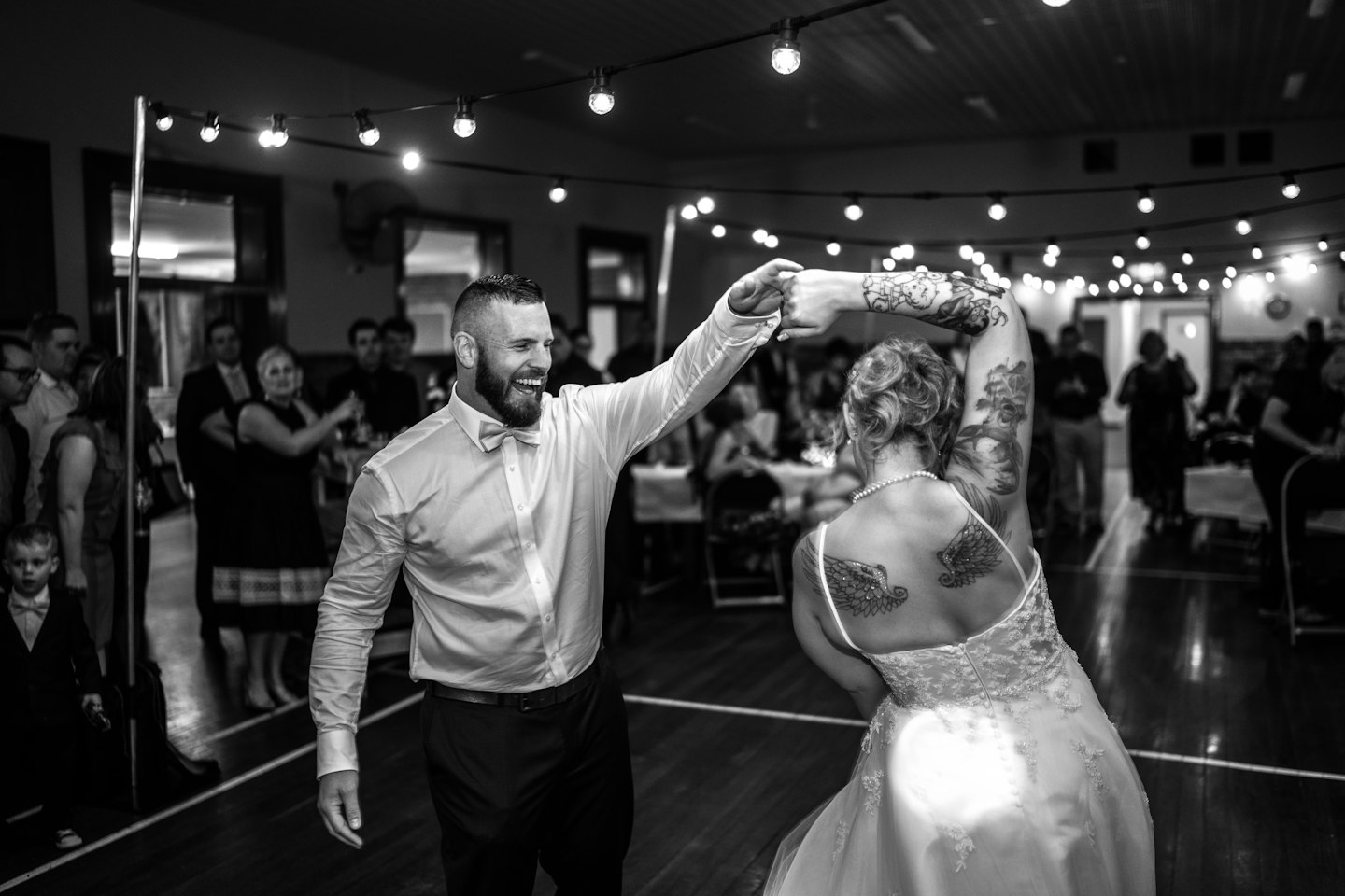 A couple dances together at an indoor wedding celebration.